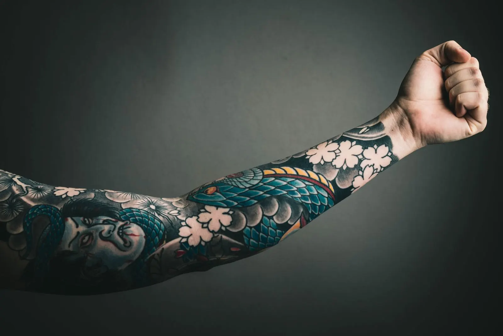 A full-colour sleeve tattoo in blues, greens and pinks