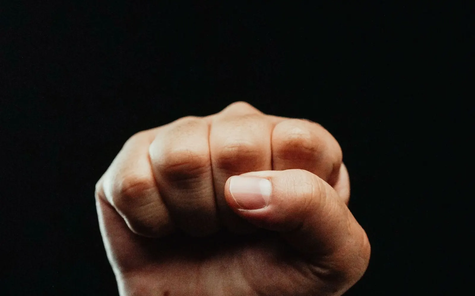 A clenched fist against a dark background
