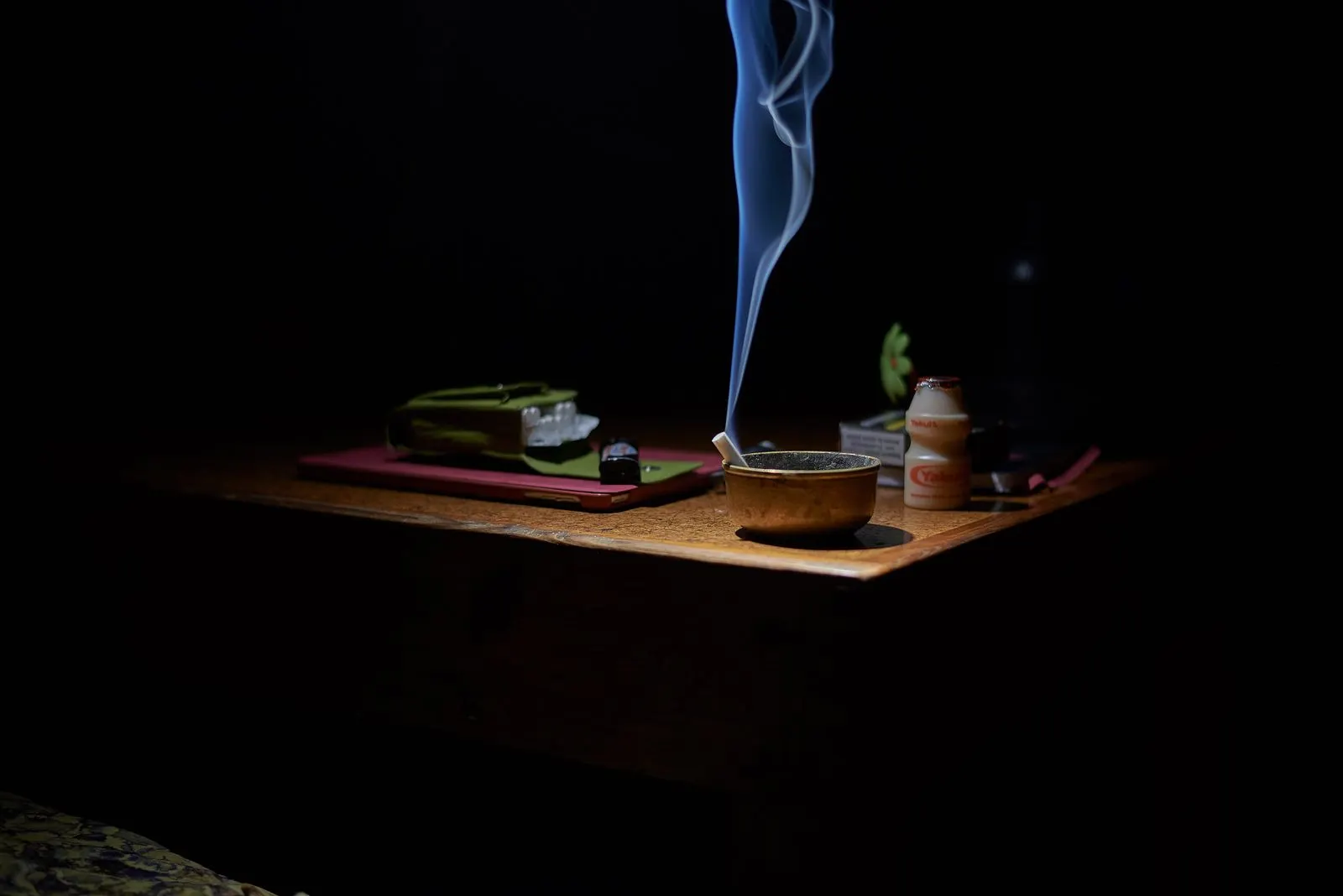 A lit cigarette in an ashtray, smoke rising