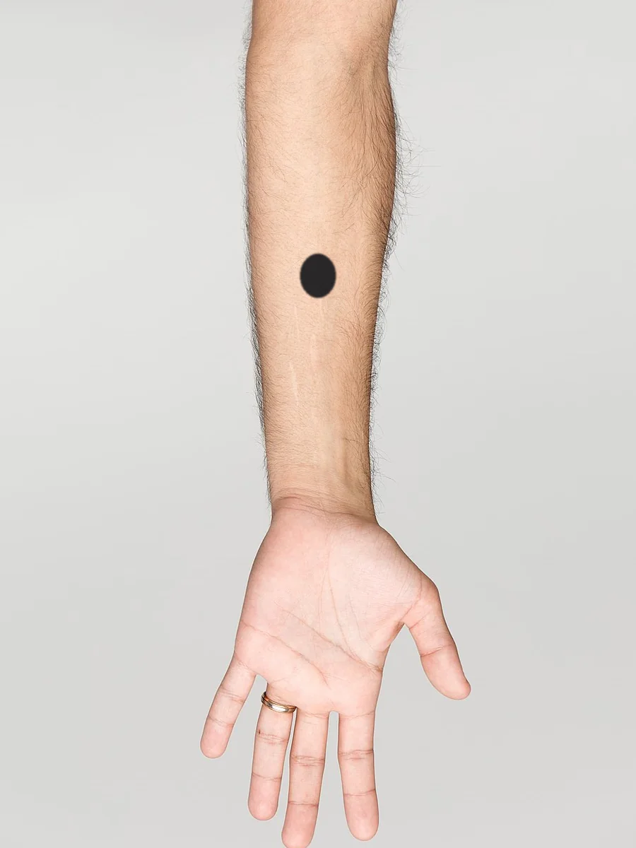 A tiny tattoo, about 2cm, on a forearm