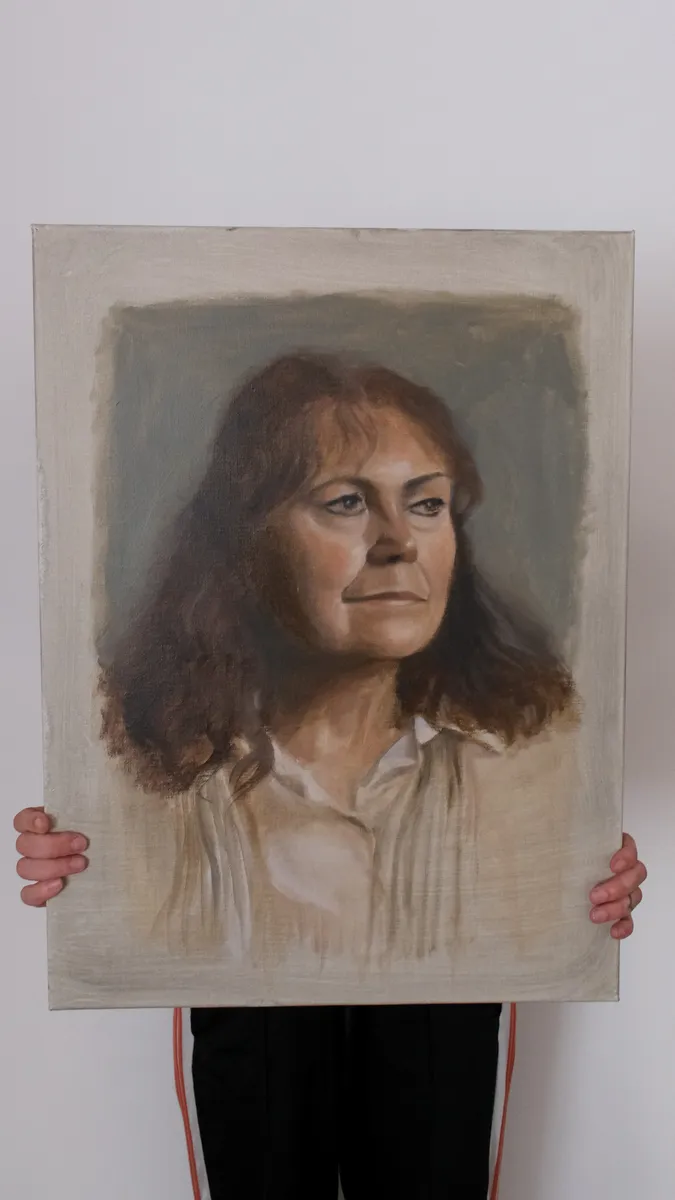 Oil portrait of a woman with auburn hair, held up by Britt Beale