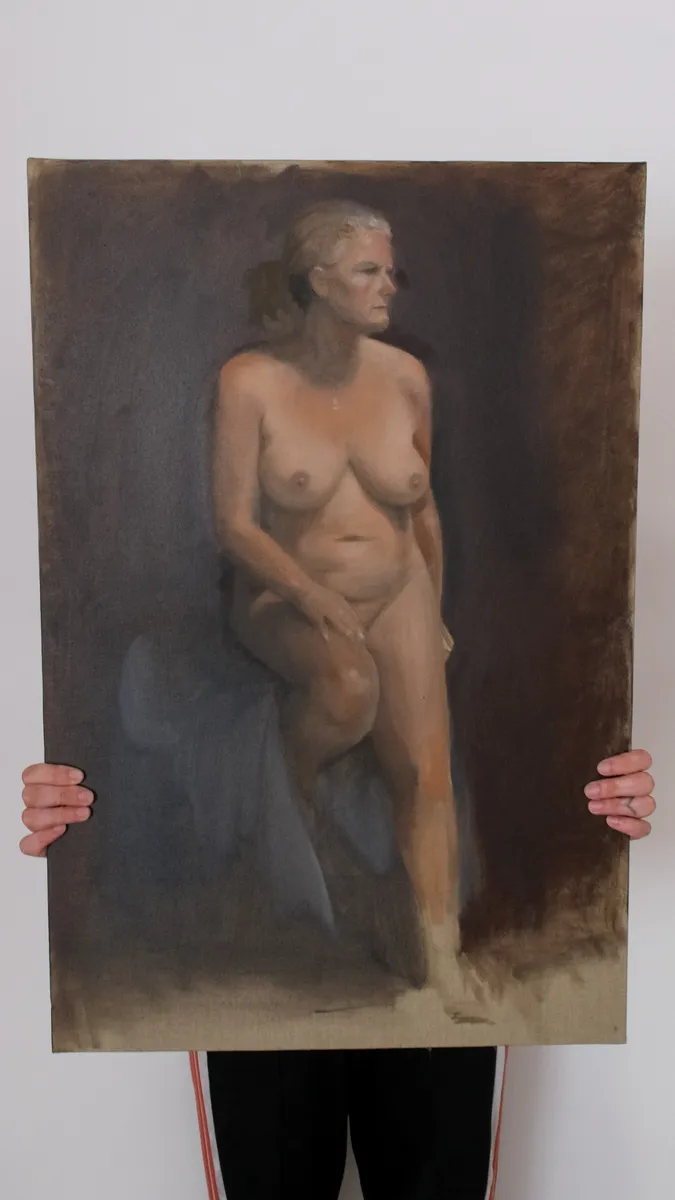 Oil figure painting of a seated nude, held up by Britt Beale