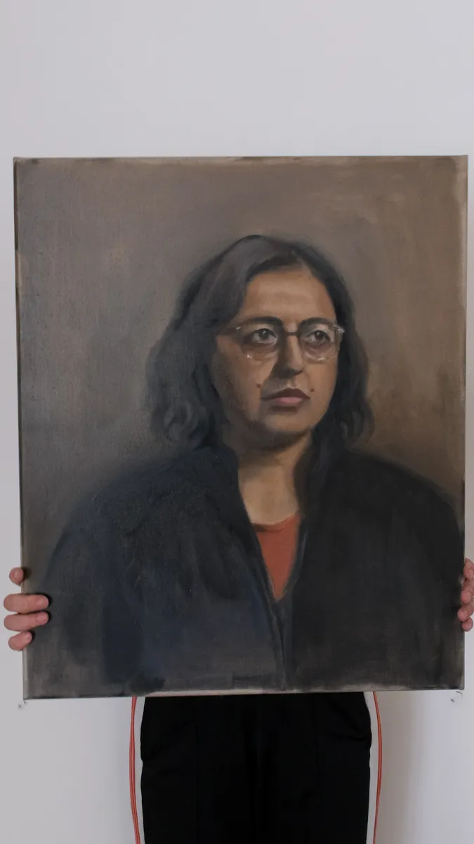 Oil portrait of a woman wearing glasses, held up by Britt Beale