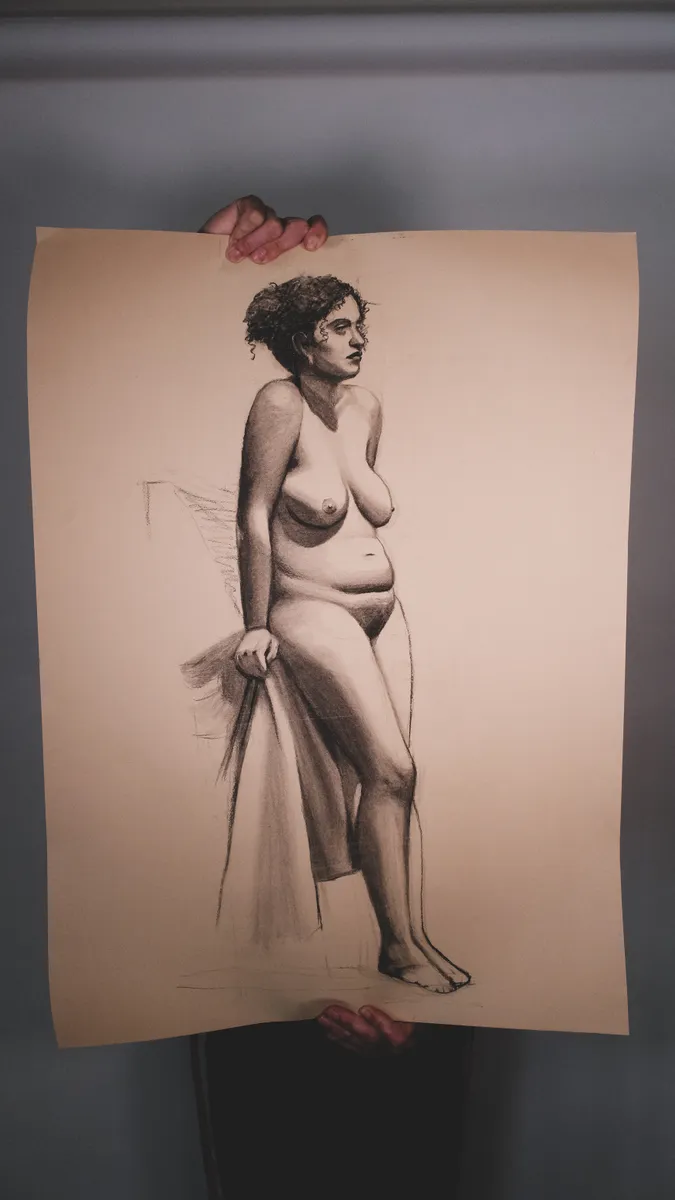 Figure drawing of a standing nude, on toned paper, held up by Britt Beale
